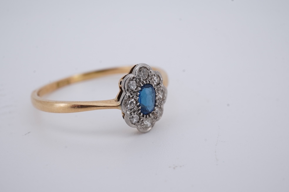 A 1920's yellow metal, stamped 18ct, sapphire and diamond set oval cluster ring, size V, gross weight 2.3 grams. Condition - poor to fair